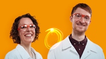 Eine BASF-Mitarbeiterin und ein BASF-Mitarbeiter mit weißen Laborkitteln und Schutzbrillen stehen vor einem orangefarbenen Hintergrund. Eine BASF-Mitarbeiterin und ein BASF-Mitarbeiter mit weißen Laborkitteln und Schutzbrillen stehen vor einem orangefarbenen Hintergrund.